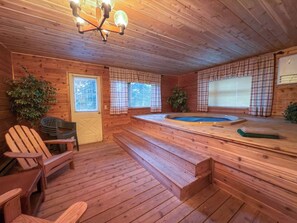 A wooden interior with a hot tub, wooden steps, and a ceiling light fixture. - 4BR Big Sky Condo with Private Hot Tub & Sauna (Big Sky)