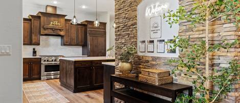 A modern kitchen with dark wood cabinets, a central island, and pendant lighting.