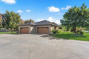 A two-story house with a garage, a driveway, and a well-maintained lawn. - 5-bdrm with hot tub, theater room & sports court in charming Eagle (Eagle)