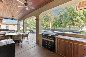 Eine Außenpatio mit Grill, Sitzgelegenheit und Blick auf die Nachbarschaft.