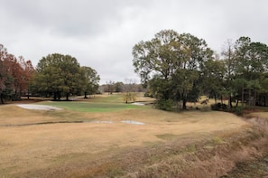 A golf course with sand bunkers, a putting green, and a variety of trees. - Polished Guest Suite With Balcony Overlooking Golf Course in Charleston, SC (Charleston)