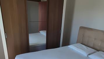 Ein Schlafzimmer mit einem Bett, einem Kleiderschrank und einem Spiegel.