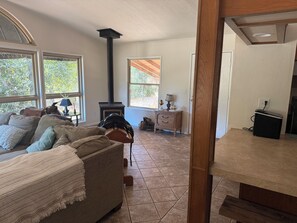 A cozy living room with a fireplace, a sofa, a coffee table, and a lamp. - Riverside Horse Ranch Unplugged (Thornton)