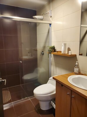 A bathroom with a shower, toilet, and sink. - QuitoVibes4U ¡Elegante, ubicación privilegiada, acogedor! (Quito)