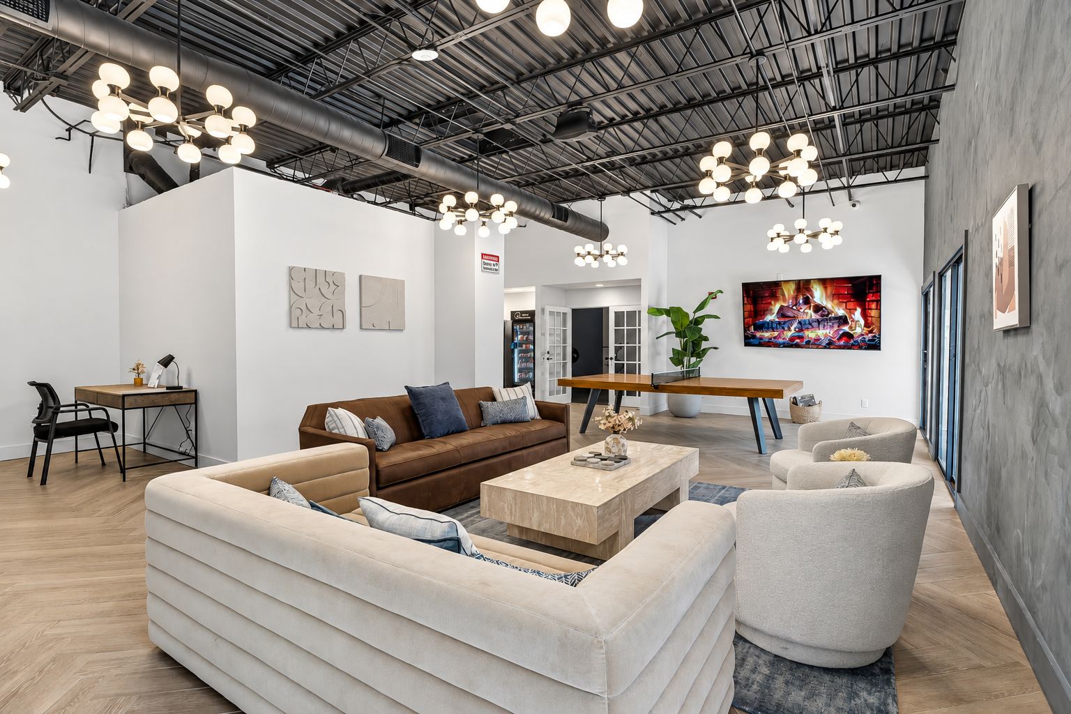 A modern living room with a sofa, armchairs, a coffee table, and a TV.