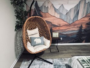 A room with a hanging chair, a framed picture, and a wall mural. - Cozy 2 Bedroom Retreat in the Heart of Cary, Near SAS (Cary)