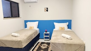 A twin room with two beds, a small table, and a window. - Comfort on Praia do Futuro by Reserva Mar (Fortaleza)