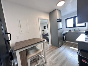 Eine moderne Küche mit Einbauofen, Kühlschrank und einem Fenster über der Spüle.