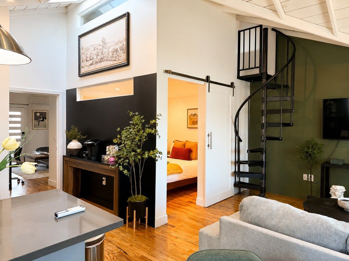 Un espace de vie moderne comprenant un escalier, un lit et un coin repas.