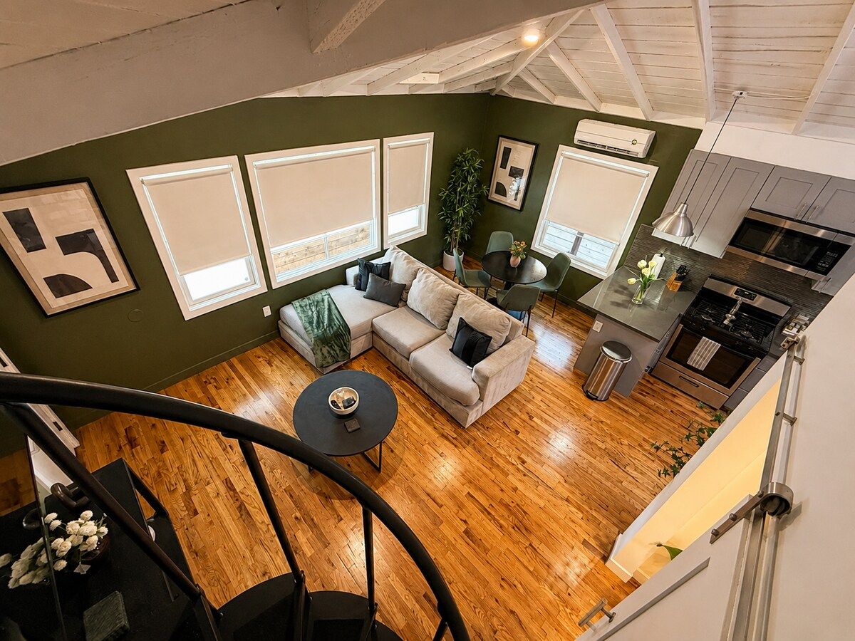 Ein modernes Interieur mit Treppe, einer Couch, einem Esstisch und einer Küchenzeile.