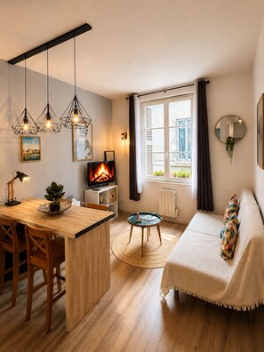 A modern living room with a wooden dining table, a sofa, and a TV. - Le Passage du Colbert - Comfort & Design - Downtown (Tours)