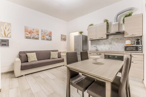 Eine moderne Küche mit Essbereich, einer Couch und Kunstwerken an den Wänden.