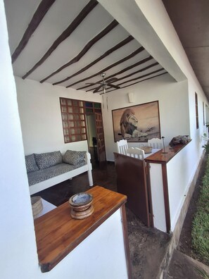 Una habitación con un sofá, una mesa con un tazón, un ventilador de techo y un cuadro en la pared.