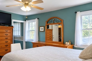 A bedroom with a bed, dresser, mirror, ceiling fan, and windows. - 3 Miles to Furniture Market • 8 Beds • Fast Wi‑Fi • Lake Views (High Point)