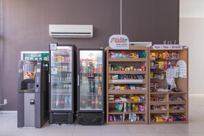 A vending machine, a refrigerator, and a shelf stocked with snacks and beverages. - Cozy 1-bedroom apartment in fantastic Rio de Janeiro with AC and gym (Rio de Janeiro)