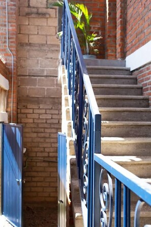 A staircase with blue handrails and brick walls. - Boutique Bucerías Hacienda | Spacious Private Terrace (Bucerías)