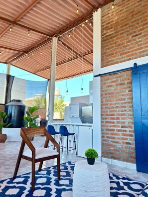 An outdoor patio area with a barbecue grill, seating, and a view of the sky. - Boutique Bucerías Hacienda | Spacious Private Terrace (Bucerías)