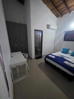 Quarto com cama, escrivaninha, cadeira e guarda-roupa.