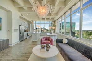 A modern kitchen with a central island, a dining area with a round table, and a sofa with a view of the city. - Downtown/FreeParking/Rooftop Pool/ King Plush Beds (Atlanta)