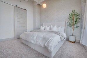 A bedroom with a bed, a potted plant, and a sliding door. - Downtown/FreeParking/Rooftop Pool/ King Plush Beds (Atlanta)