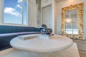A modern living room with a round white coffee table, a black spherical object, and two books. - Downtown/FreeParking/Rooftop Pool/ King Plush Beds (Atlanta)
