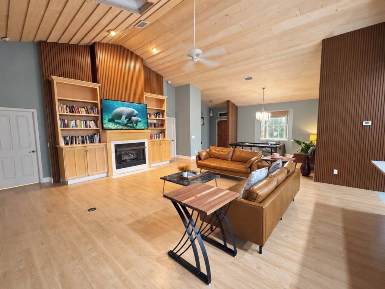 Un salon spacieux avec une cheminée, un téléviseur, un canapé et une table basse.