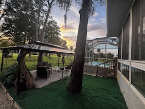 A covered outdoor area with a pool, artificial grass, and a patio with furniture. - Afterglow Manatees:Pool /Golf/Near Spring/Spacious (Crystal River)