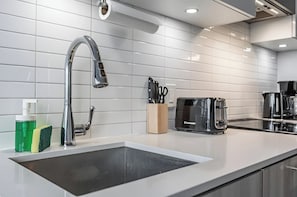 A modern kitchen with a stainless steel sink, a toaster, and a coffee maker. - The Boutique Suites - Jarvis Street (Toronto)