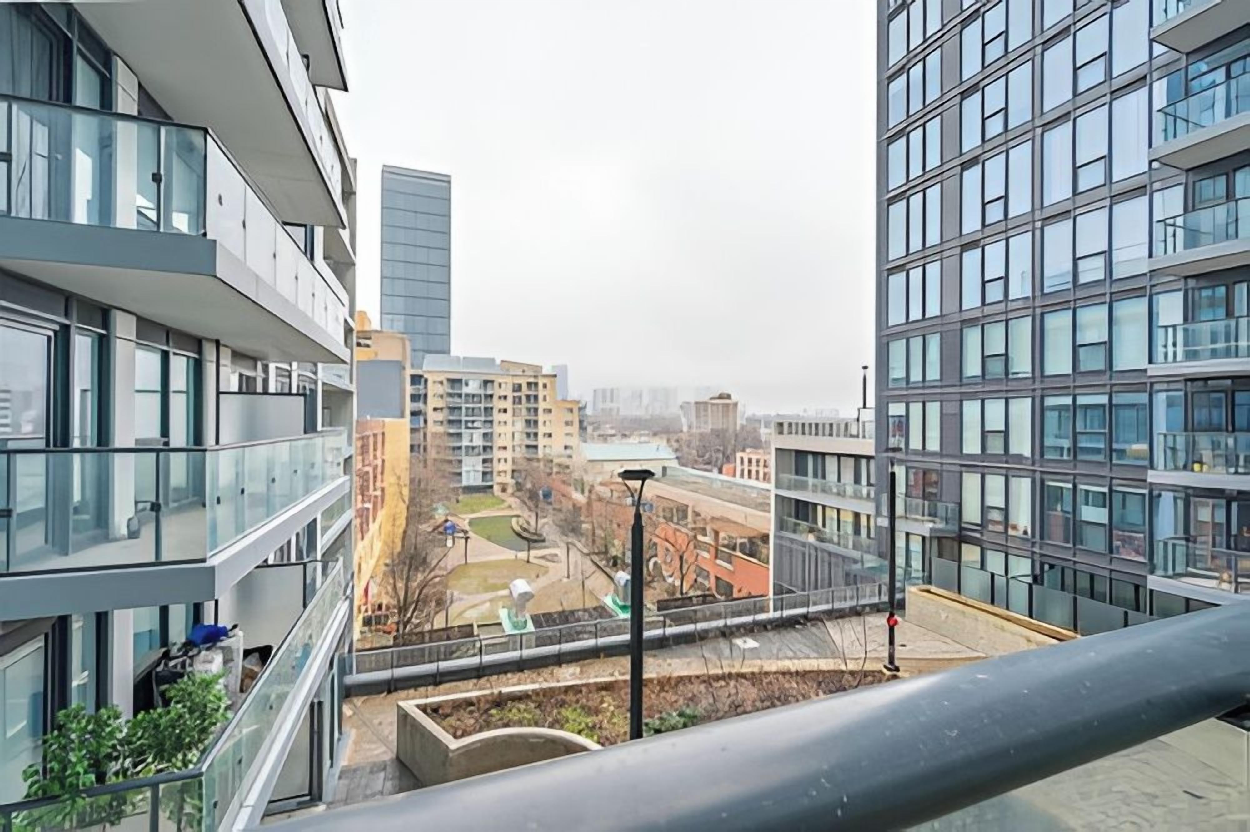 Un bâtiment moderne à étages, doté de grandes fenêtres et d’une cour intérieure avec un espace de jeux pour enfants.