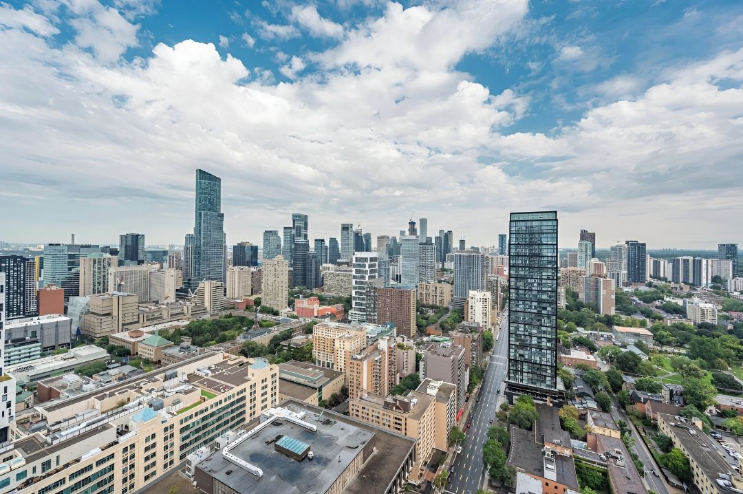 A cityscape with modern high-rise buildings, a mix of commercial and residential structures, and a clear sky.