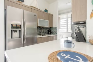 A modern kitchen with stainless steel appliances, a microwave, and a water dispenser. - * * CASA PALMA * *  Beachside Tropical Oasis (Ensenada)