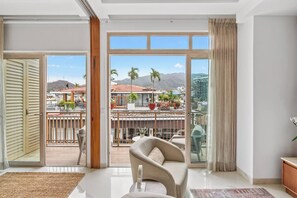A modern living room with a balcony, large windows, and a view of a cityscape. - Penthouse 1BR | Rooftop Pool, Hot Tub & Romantic Zone (Puerto Vallarta)