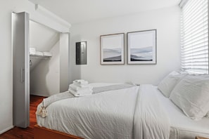 A bedroom with a bed, a closet, and two framed pictures on the wall. - Rooftop Retreat w/ Stunning Views Ballard Gem (Seattle)