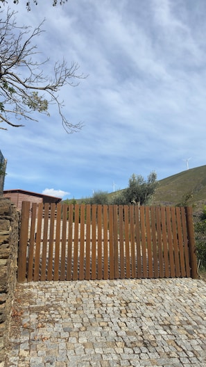 A wooden fence with a stone wall and cobblestone ground.