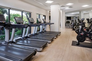 A gym with multiple treadmills aligned in a row, a variety of exercise machines, and large windows providing natural light. - Westin Kierland Villas · 2BR Sleeps 8 · Golf Views, Pools & Resort Amenities (Scottsdale)