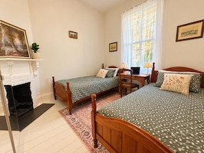 A bedroom with two single beds, a desk with a laptop, a fireplace, and a large window with curtains. - Entire 3BR Beachside House in the Heart of St Kilda (St Kilda)