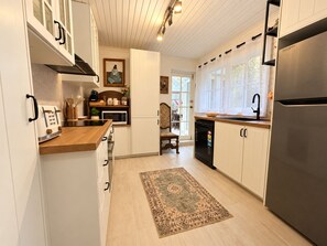 A kitchen with white cabinets, a stainless steel refrigerator, a microwave, and a toaster. - Entire 3BR Beachside House in the Heart of St Kilda (St Kilda)