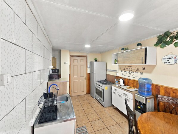 A compact kitchen with a stove, sink, and refrigerator.