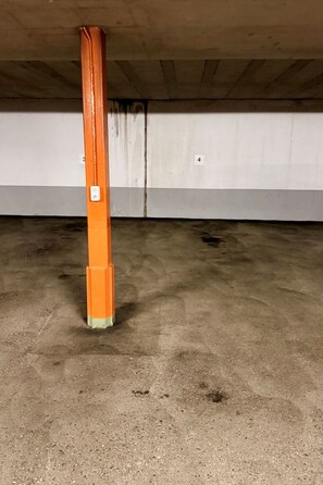 A concrete pillar with a white label, a concrete floor, and a grey wall. - Waldhaus A1/4 (CharmingStay), (Flumserberg Tannenboden), by Interhome (Flumserberg Tannenheim)
