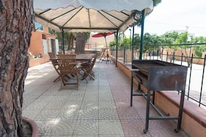 An outdoor patio with a covered seating area, a grill, and a tiled floor. - Villa Adelaide | Private Pool, 5 Bedrooms, and the Ocean Just 100 Meters Away (Reggio Calabria)