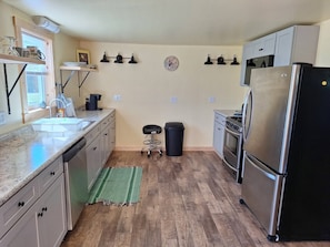 A compact kitchen with a refrigerator, stove, and sink.