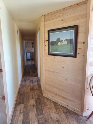 A wooden interior hallway with a framed picture on the wall.