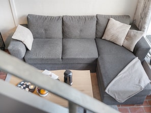 A grey sectional sofa with a wooden coffee table, a book, and a kettle. - "Alena" - 50m from the sea by Interhome (Brovst)