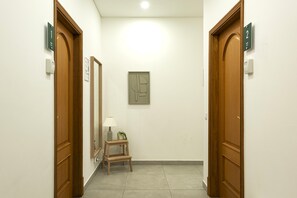 Bright, minimalist corridor with rooms 1 & 2, mirror and lamp