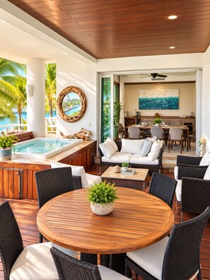A modern outdoor living area with a pool, seating, and a dining space. - Luxury Peninsula Condo with Canal and Ocean Views / Newly Renovated / 3 Bedrooms (Puerto Aventuras)