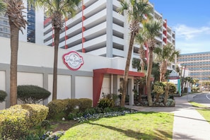 Ein Hotel mit roter und weißer Fassade, Palmen und einem Schild mit der Aufschrift 'Blue South'.