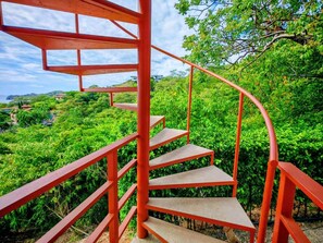 Eine Wendeltreppe mit roten Gel ändern führt zu einer üppigen Grünanlage.