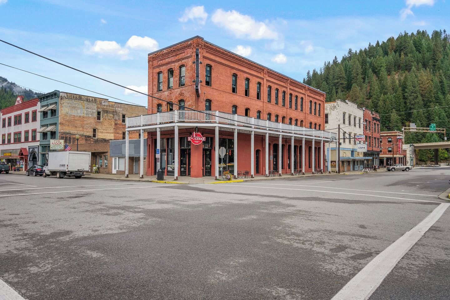 A historic building with a red facade, a balcony, and a sign indicating a restaurant.