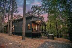A cabin with a porch and staircase, surrounded by trees. - "Rest & Redeem" New Luxury Cabin in Broken Bow (Broken Bow)