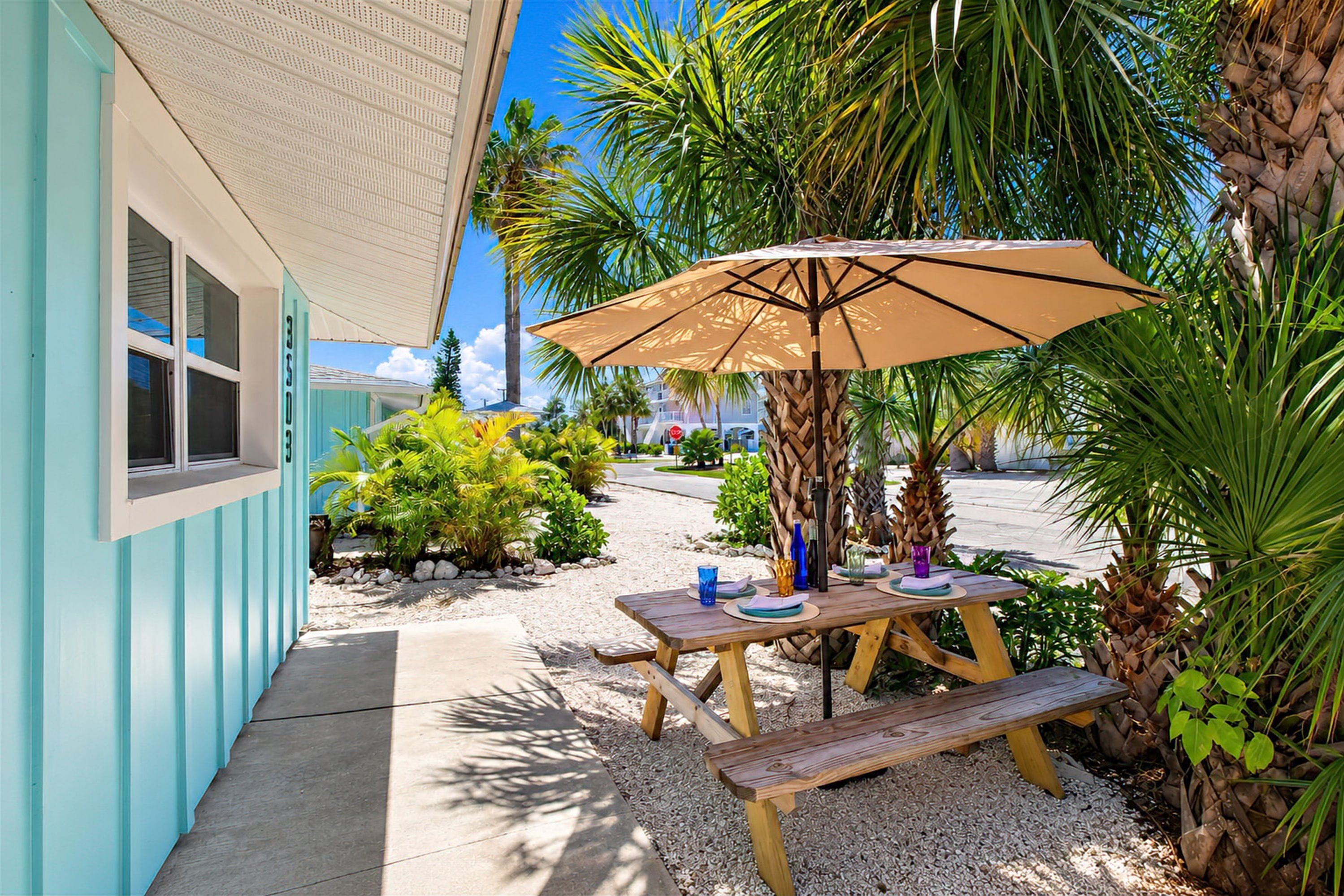Tropical outdoor dining nook with shaded picnic table and palm views